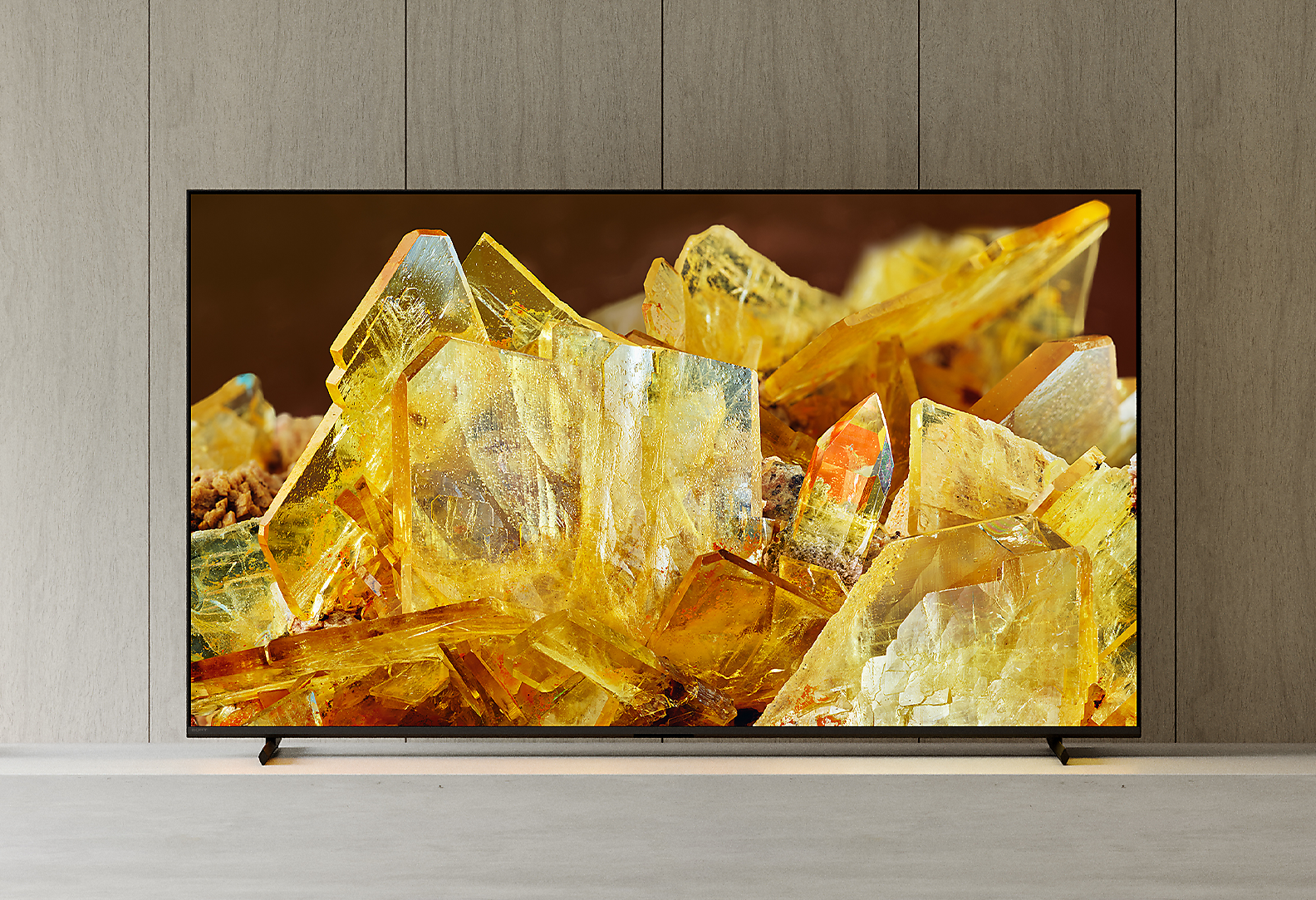 客廳中的 BRAVIA XR 電視，螢幕上顯示琥珀色水晶的特寫圖片